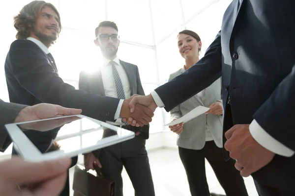 Anställda ser på de handshake affärspartnerna — Stockfoto