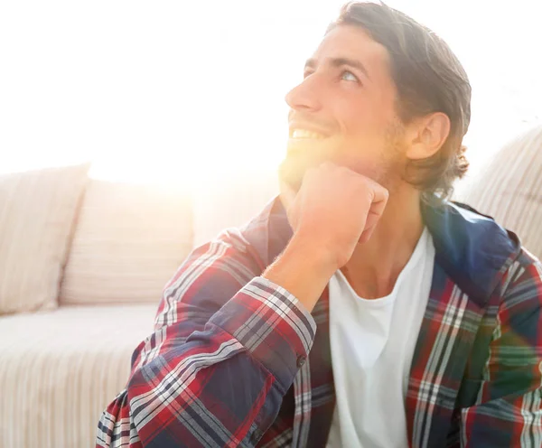 Close-up van een gelukkig man zittend op het tapijt in een nieuw appartement. — Stockfoto