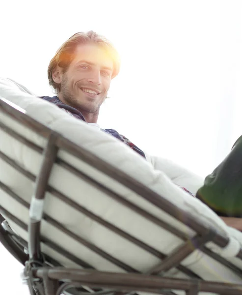 Primo piano. il ragazzo sta riposando seduto su una grande sedia comoda . — Foto Stock