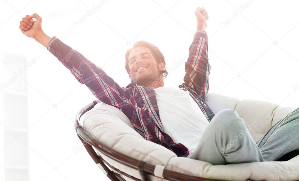 stylish guy stretching in a comfortable chair