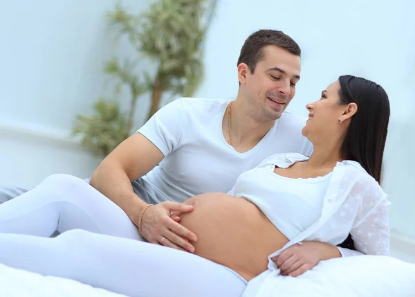 Marido e mulher grávida deitada na cama no quarto . — Fotografia de Stock