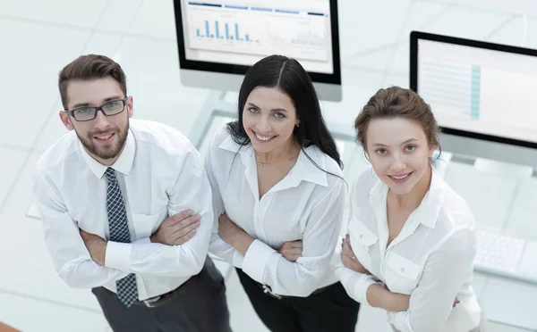 Equipo empresarial exitoso de pie cerca del lugar de trabajo —  Fotos de Stock