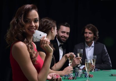 siyah arka plan üzerine poker oynamaya genç esmer kadın