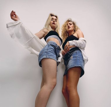 Beyaz duvara yakın alt view.two sarışın kadının....