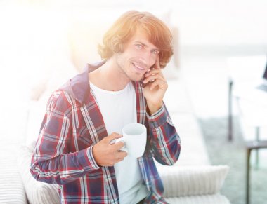 güzel bir fincan adamla bir dizüstü bilgisayar önünde oturur.