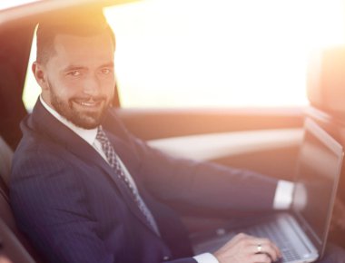 Otomatik olarak oturan dizüstü bilgisayar ile kendine güvenen iş adamı.