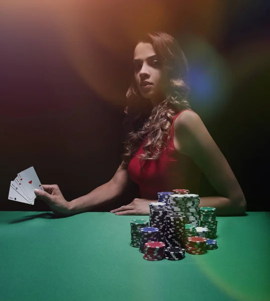 Pretty young woman gambling on green table — Stock Photo, Image