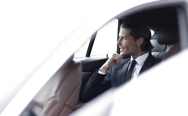 Erfolgreicher Mann sitzt auf dem Rücksitz eines Autos — Stockfoto