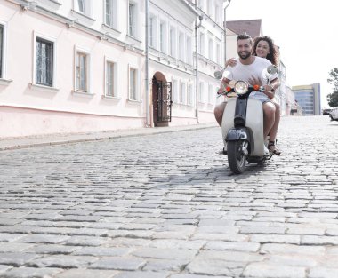 mutlu genç bir çift bir scooter üzerinde eğleniyor