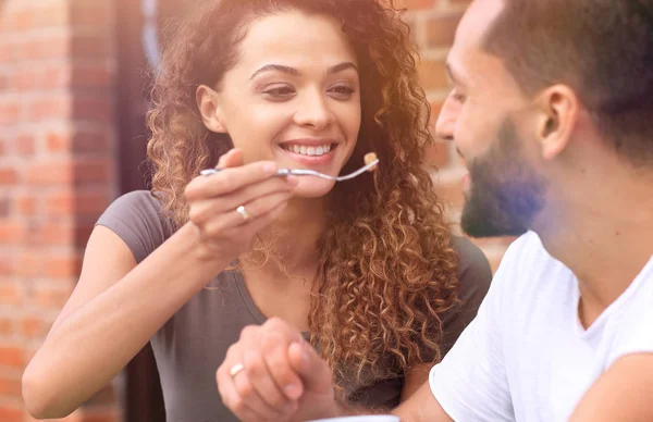 Jovem casal desfrutando de café em um café de rua e rindo — Fotografia de Stock