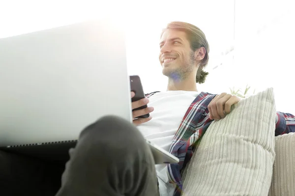 Successful guy sitting on sofa in living room — Stock Photo, Image