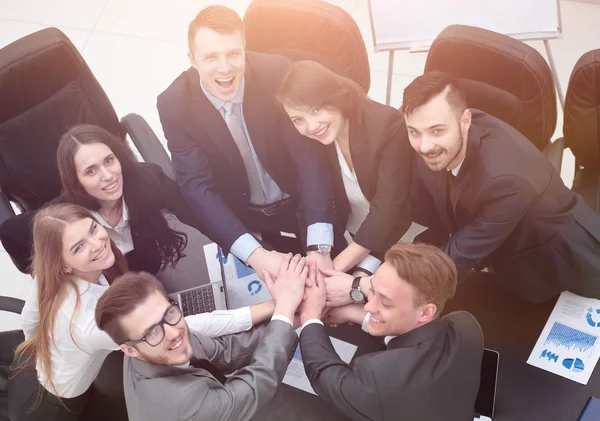 Equipe de negócios com as mãos apertadas juntas na mesa — Fotografia de Stock