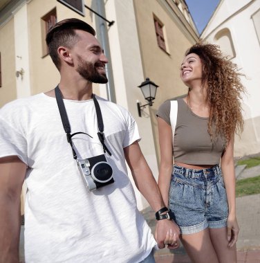 Bir çift şehrin sokaklarında yürüyor ve eğleniyor.