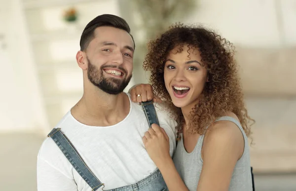 Glückliche junge Leute stehen in einem neuen Haus — Stockfoto