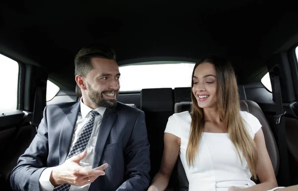 Young business team sitting on the backseat of a taxi — Stock Photo, Image