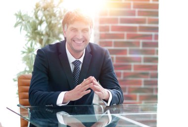 Bir boş konferans salonunda bir masada oturan proje yöneticisi