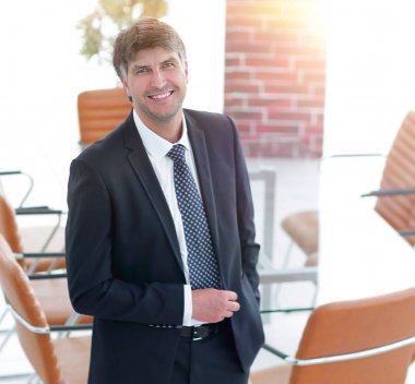 Bir boş toplantı odasında duran iş adamı