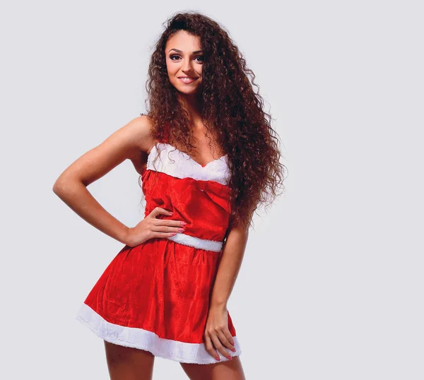 Ung flicka i kort klädd som jultomte leende. — Stockfoto