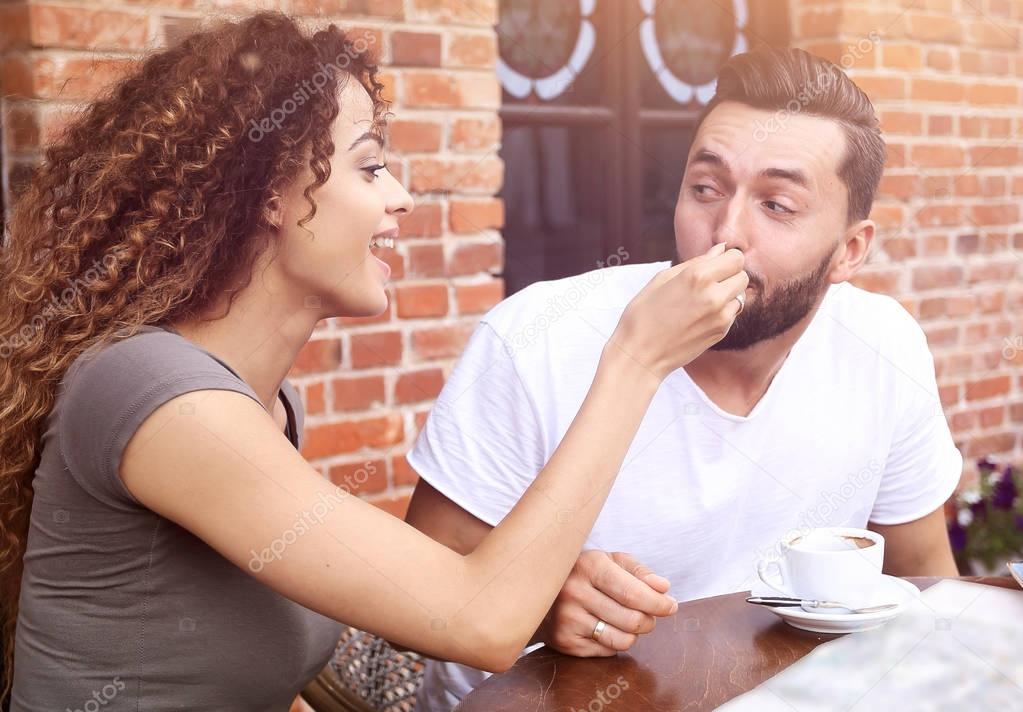 Young tourists eating breakfast at restaurant table outside side