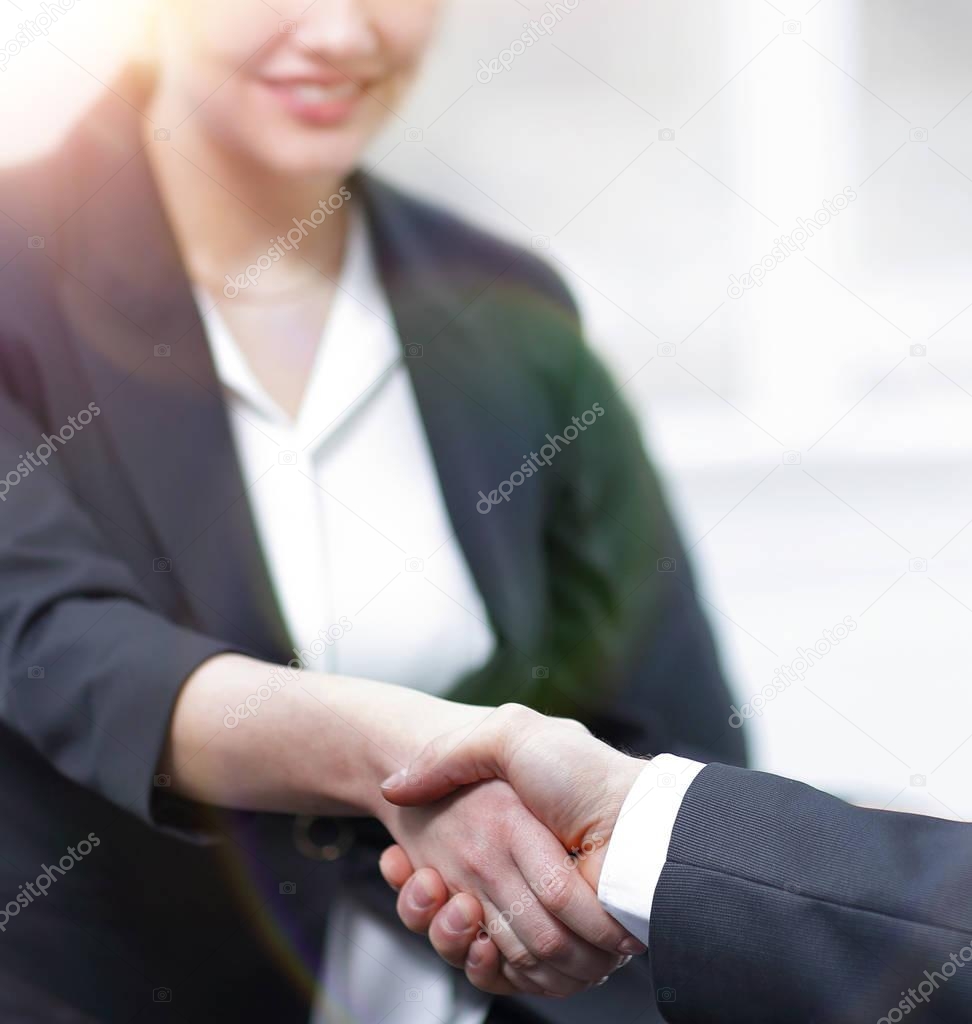closeup of business woman shaking hands with her colleague.