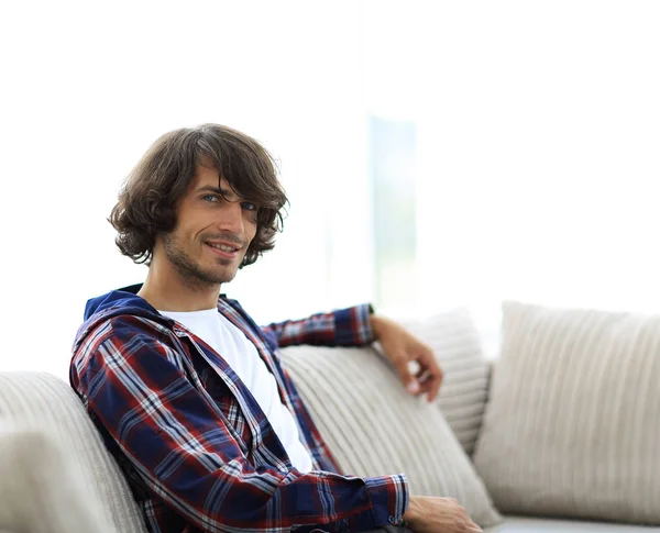 Красивый успешный парень, сидящий на диване . — стоковое фото