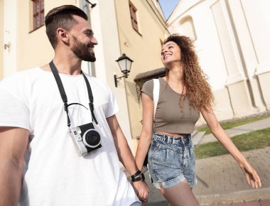 Bir çift şehrin sokaklarında yürüyor ve eğleniyor.