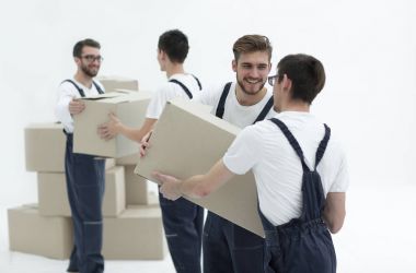 Kutu üzerinde beyaz backgro izole gülümseyen tutan Nakliyeciler portresi