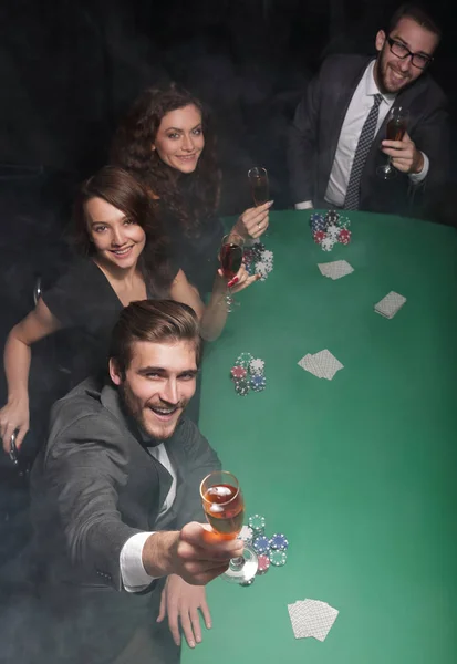 Grupo de amigos sentados en una mesa de casino — Foto de Stock