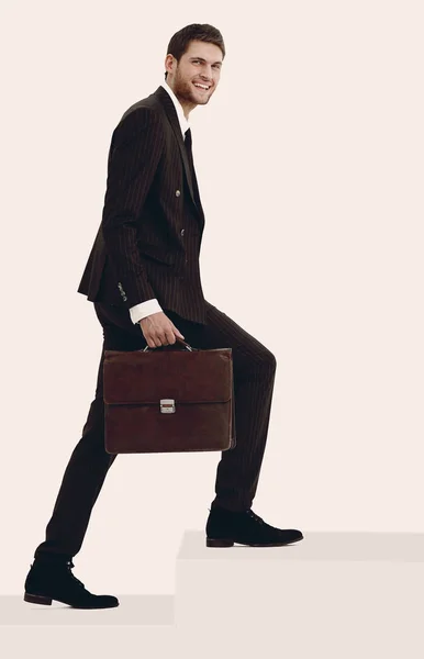 En pleno crecimiento. un hombre de negocios con un maletín de cuero se acerca . —  Fotos de Stock