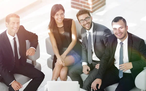 Portret van een lachende business team zit in de lobby van het kantoor — Stockfoto