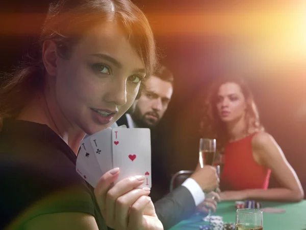 Portrait du joueur féminin à la table de poker avec des cartes — Photo