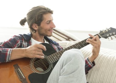 oturma odasında kanepede oturup gitar ile Modern adam.