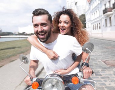 Mutlu çift sürme vintage scooter açık havada.