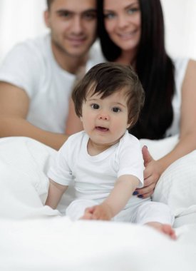 mutlu çift ve yatakta oturmuş oğul