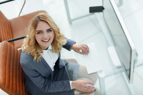 Femme d'affaires souriante assise derrière un bureau — Photo