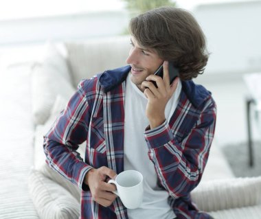 güzel bir fincan adamla bir dizüstü bilgisayar önünde oturur.