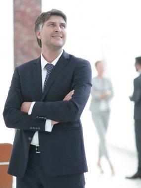 Kollarını kavuşturmuş çekici bir iş adamının fotoğrafı.