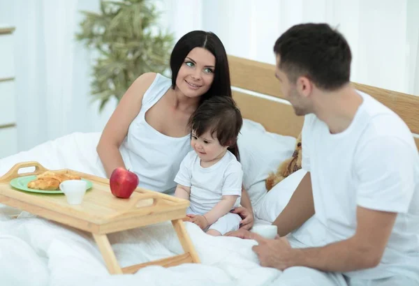 Familia tomando el desayuno en la cama en el dormitorio —  Fotos de Stock