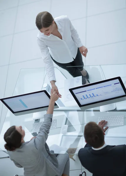 Kilátás a tetején. kézfogás menedzser és a munkavállaló az asztalon keresztül — Stock Fotó