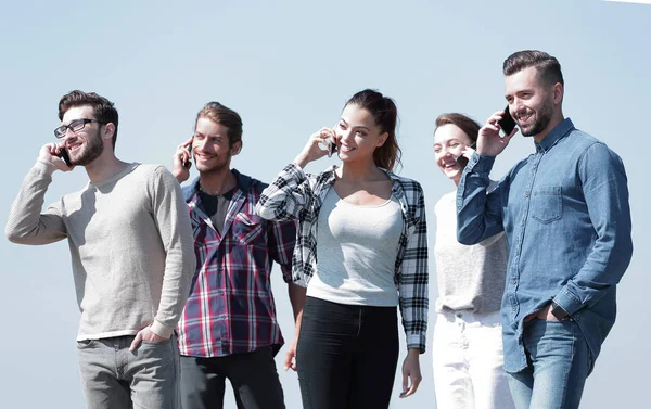 Skupina mladých lidí s chytrými telefony — Stock fotografie