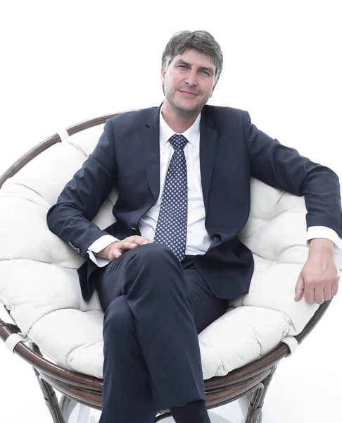 Başarılı bir iş adamı yumuşak bir rahat sandalyede oturur. — Stok fotoğraf