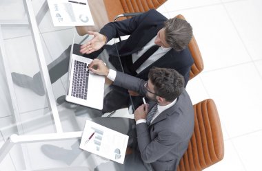 dizüstü bilgisayarda çalışan iki iş adamı