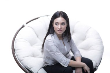 Genç kadın bir yuvarlak rahat yumuşak büyük sandalyede oturuyor.