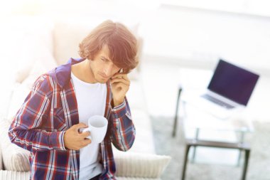 güzel bir fincan adamla bir dizüstü bilgisayar önünde oturur.