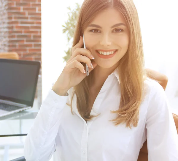 Close seup.female assistant talking on mobile phone in office — стоковое фото