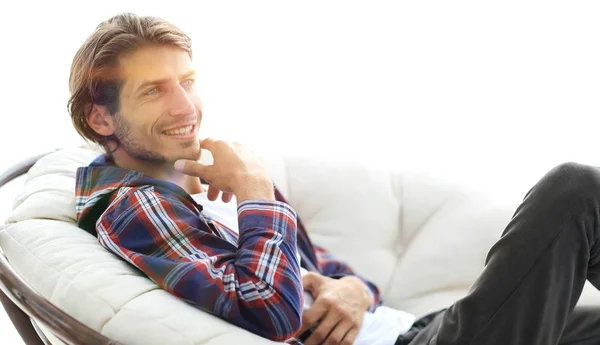 Close-up. Glimlachende man rust in een grote comfortabele stoel — Stockfoto