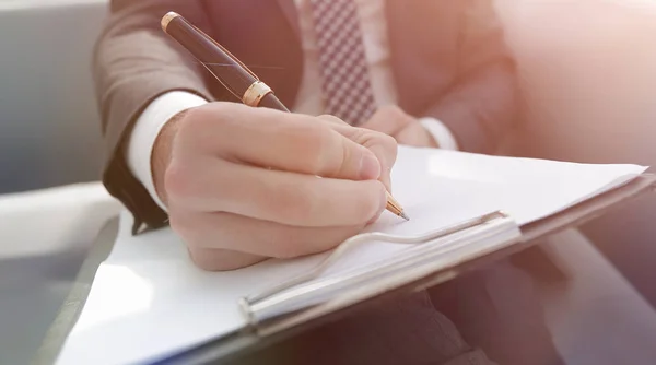 Affärsman tecknar avtal. Håller pennan i hand. — Stockfoto