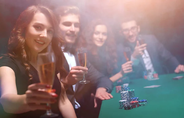 Modefrau mit Weingläsern sitzt an einem Tisch in einem Casino — Stockfoto
