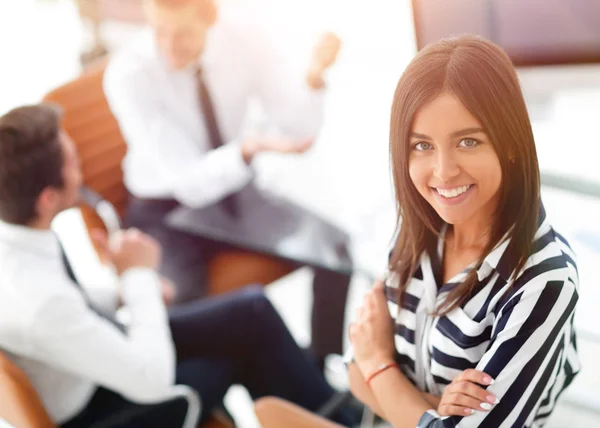 Joven mujer de negocios sentada en el escritorio en la oficina — Foto de Stock