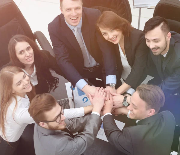 Geschäftsteam mit auf dem Schreibtisch zusammengefalteten Händen — Stockfoto